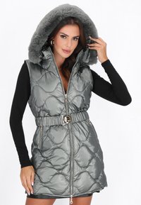 Vesta gri captusita cu gluga din blana artificiala, talie normata, si design matlasat. Dispune de fermoare frontale si accesorii decorative.