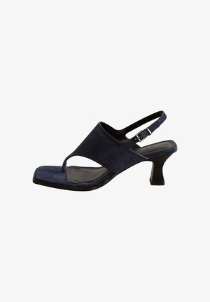 Granatowy zamszowy sandał na pasku z odkrytą piętą, z kwadratowym noskiem, zakrzywionym wzorem wycięć i niskim, szerokim obcasem. Regulowany pasek z klamrą.
