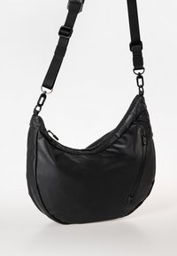 Zwarte leren hobo-tas met een gebogen vorm, een afneembare schouderband en een buitenvak met rits voor extra functionaliteit.