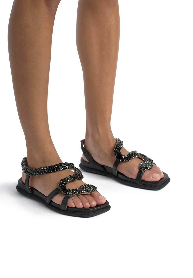 Schwarze flache Sandalen mit geflochtenem Design und mit Perlen verziert, glatte Oberfläche und offene Zehen, geeignet für den Alltag.