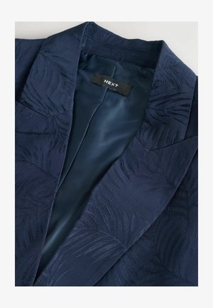 Blazer blu navy con un motivo a foglia di palma testurizzato, dotato di una morbida fodera in raso e di un'etichetta con la dicitura "NEXT" sul colletto interno.