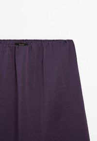 Lila Maxirock aus leichtem Stoff mit elastischem Bund, der eine glatte Textur und ein einfaches, fließendes Design aufweist.