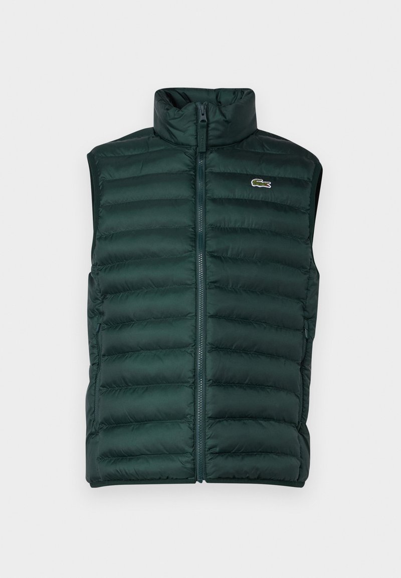 Ciemnozielona kamizelka puchowa z wysokim kołnierzem, zamkiem błyskawicznym z przodu i poziomym wzorem pikowania. Posiada haftowane logo na lewej piersi.