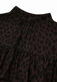 Tumma violetti paita, jossa on musta leopardikuvio, pleated-muotoilu ja röyhelöhelma. Silkkinen materiaali, joka on sileä ja pehmeä.