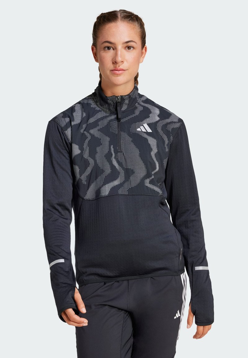 Quarter-zip long-sleeve top in black with a patterned gray upper, thumbholes, reflective accents, and textured fabric.