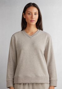 Lichtbeige sweatshirt met een V-hals, lange mouwen en een getextureerde, quilterrand. Zachte stof met een gladde afwerking, ontworpen voor casual wear.