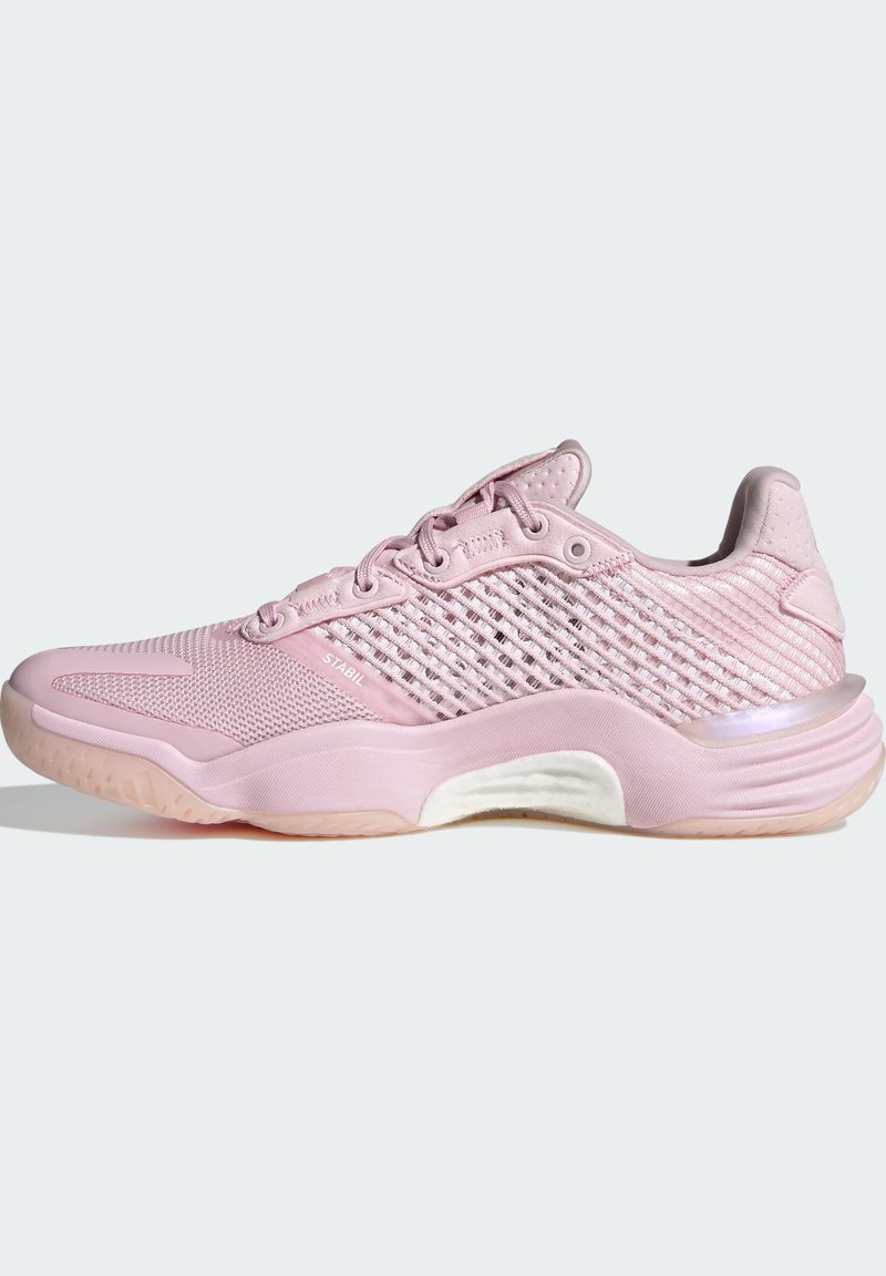 Zapatilla deportiva de color rosa claro con parte superior de malla texturizada, talón reforzado y una entresuela blanca en contraste con una suela translúcida sutil.