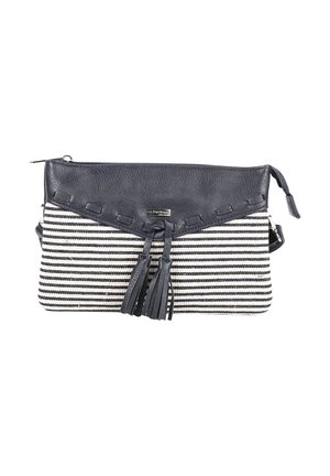 Pochette en tissu rayé noir et blanc avec rabat en cuir foncé, détails à pompons et fermeture éclair sur le dessus.