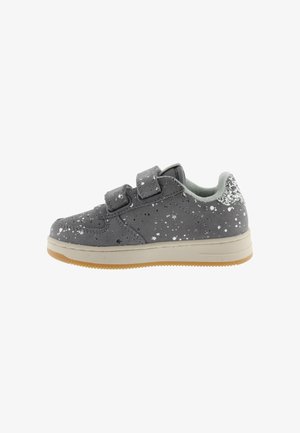 Grijze kindersneaker met witte spikkels, twee klittenbandsluitingen, een rubberen zool en een glinsterende zilveren hielkap.