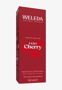 Czerwone opakowanie z brandingiem "Weleda", etykieta "Limitowana Edycja Bardzo Wiśniowa", z ilustracją wiśni. Zawiera 50 ml kremu do rąk.
