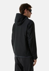 Zwarte, lichtgewicht jas met een capuchon, casual ontwerp, gladde textuur, elastische manchetten en een grijze binnenvoering. Geen opvallende logo's of patronen.