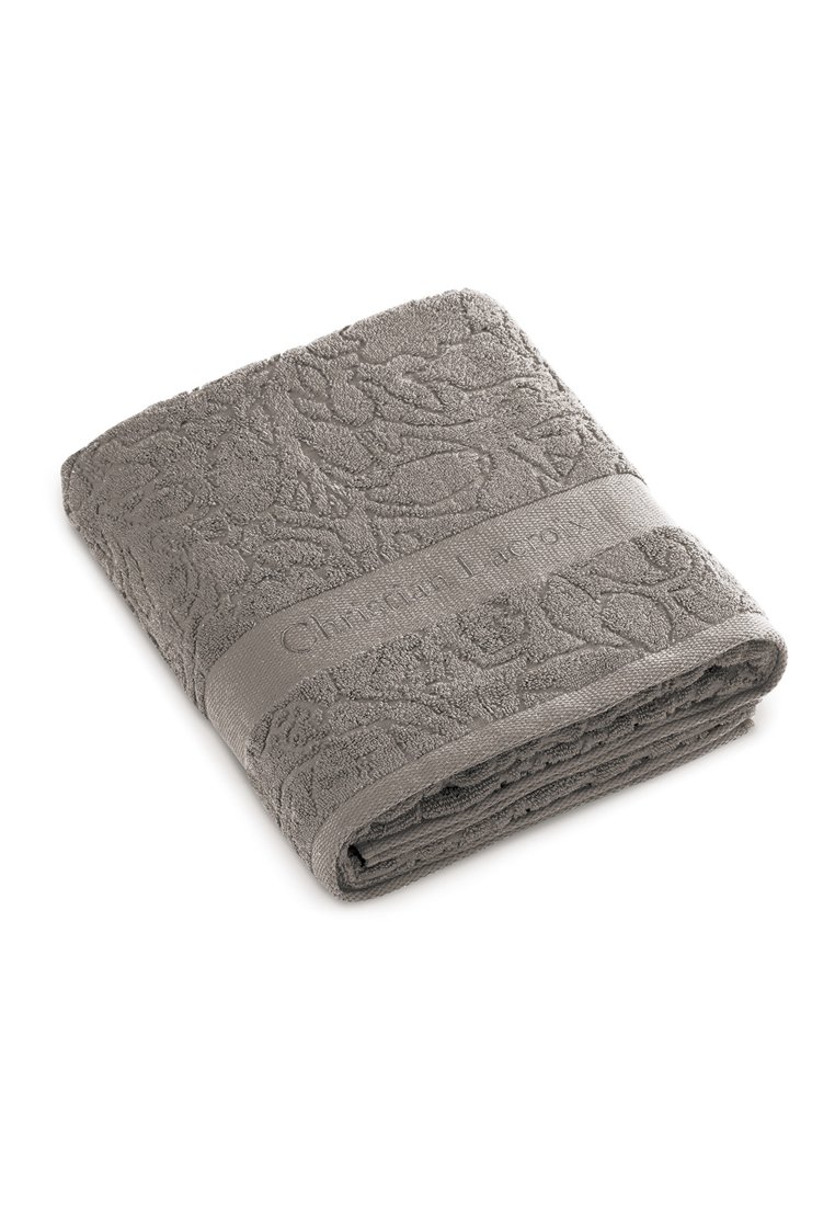 Serviette grise en coton doux avec un motif floral texturé. Elle comporte une bande unie avec un logo et est soigneusement pliée.