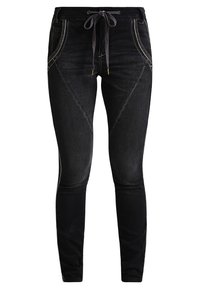 Jeans negros con un corte ajustado, hechos de denim, que presentan una cintura con cordón y costuras más claras a lo largo de las costuras laterales.