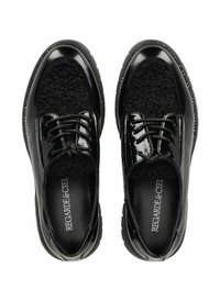 Scarpe in vernice nera con tessuto nero testurizzato nella parte anteriore, dotate di lacci rotondi e suola imbottita. Logo stampato all'interno.