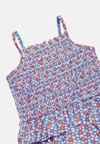 Vestido floral azul con cuerpo ajustado, tirantes finos y un dobladillo con volantes. Presenta patrones de flores rojas, rosas y blancas sobre un fondo claro.