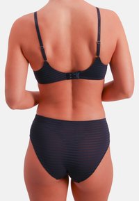 Mørkeblå bikinitop og højtaljet trusse med horisontalt stribet mønster. Justerbare stropper og lukning med spænde bagpå.