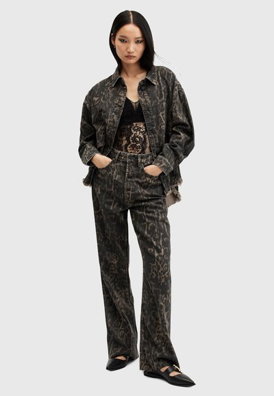 Veste en denim et pantalon gris foncé avec imprimé léopard noir, associés à un haut en dentelle noire. Doté d'un ajustement décontracté et de détails à ourlet effiloché.