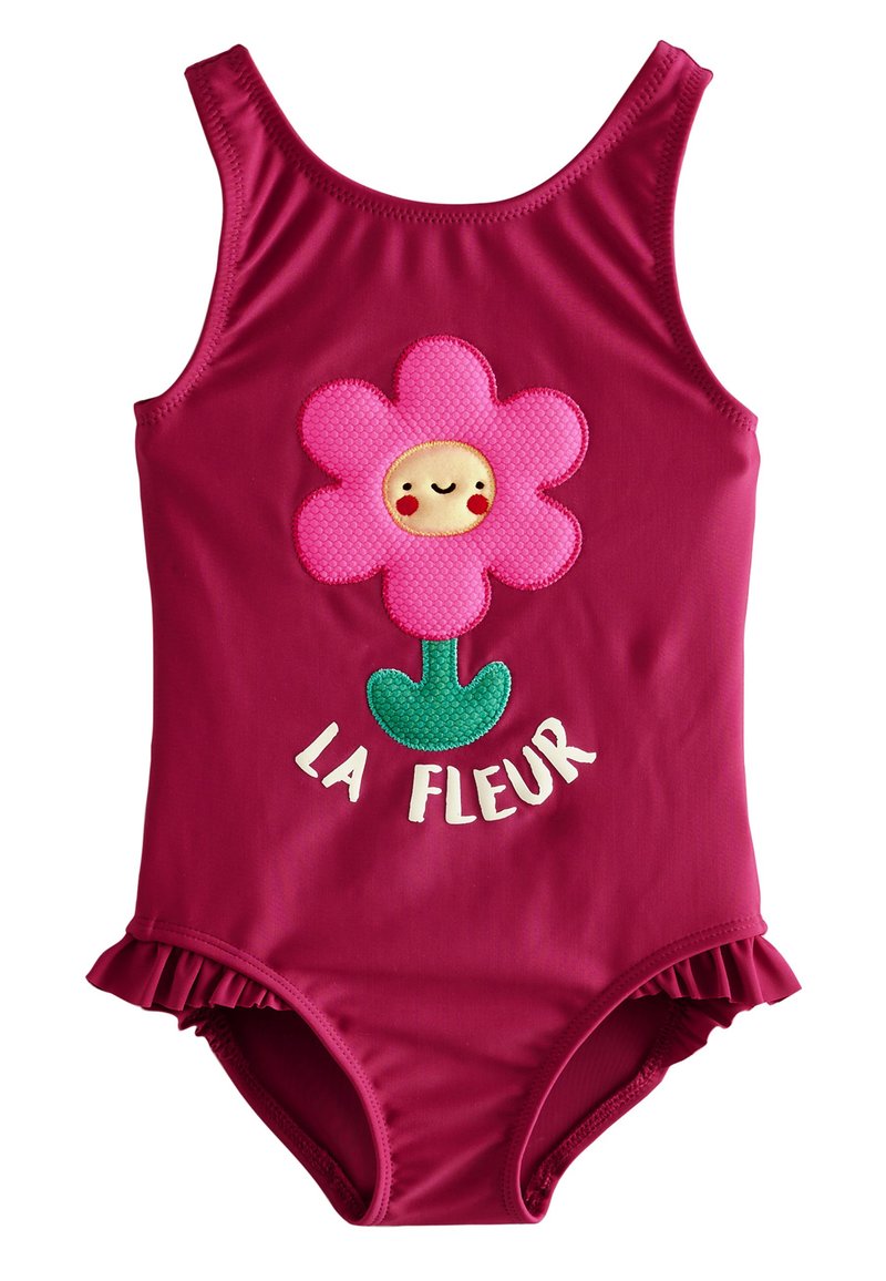 Fuchsia badpak met bloemapplicatie, voorzien van een glimlachend gezicht en gerimpelde randen; tekst "LA FLEUR" in het wit onder de bloem.