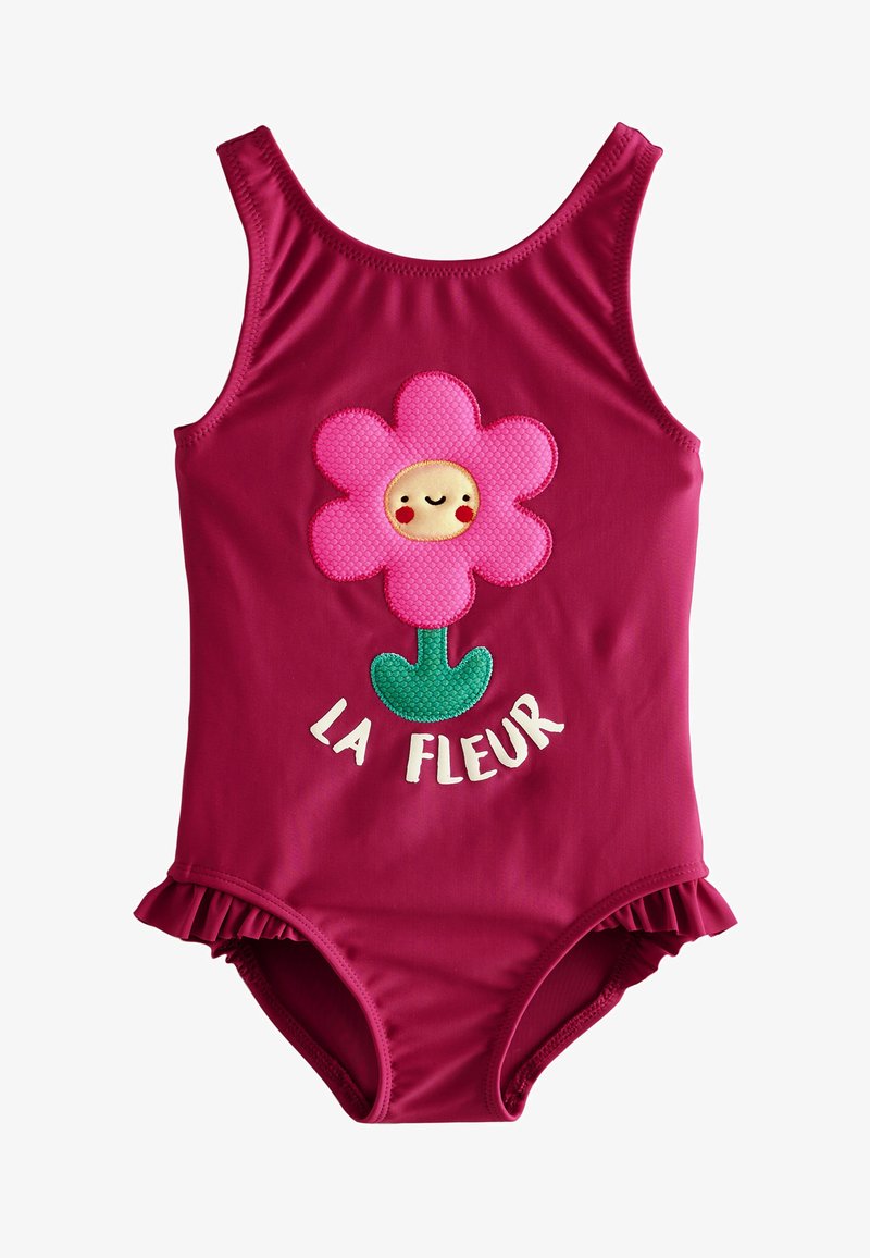 Fuchsia one-piece swimsuit with flower applique, featuring a smiling face and ruffled edges; text "LA FLEUR" in white below the flower.