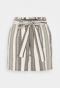 Shorts à motifs en tissu crème avec des rayures géométriques noires et un nœud à la taille. Ils présentent une coupe ample et des poches latérales.