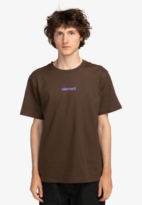 Camiseta de algodón marrón con cuello redondo y mangas cortas. Presenta un logo "element" en púrpura impreso en el pecho. Ajuste casual.