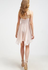 Krátké růžové šaty s volnou, průsvitnou sukní. Mají přiléhavý korzet a nastavitelné ramínka. Nosí se s béžovými vysokými podpatky.