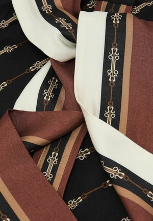 Silk fabric with brown, black, beige, and white stripes featuring a chain-link and ornamental pattern, softly folded to show texture.