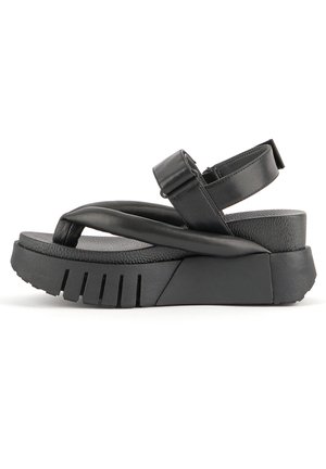 Black sandals with a thick, textured rubber sole. Features a wide cross strap and an adjustable ankle strap for a secure fit.