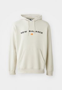 Hellbeige Kapuzenpullover mit Kordelzug, Fronttasche und schwarzem "NEW BALANCE"-Text. Weicher Stoff mit gerippten Bündchen und Saum.