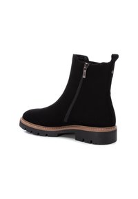 Stivali alla caviglia in suede nero con cerniera laterale e punta arrotondata. Presentano una base cucita marrone e una suola in gomma spessa per una buona aderenza.
