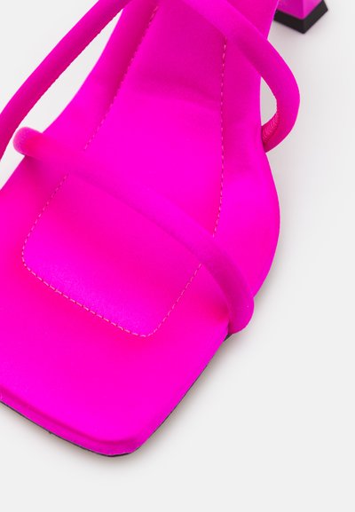 Sandália aberta em camurça fúchsia com duas tiras finas, bico quadrado e um pequeno salto em bloco preto. Apresenta detalhes de costura em contraste.