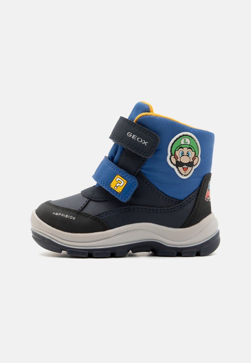 Bottes Geox en bleu et noir avec des accents jaunes, deux bandes Velcro et un patch de personnage. Fabriquées en matériaux synthétiques, semelle texturée.