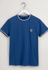 Niebieski bawełniany t-shirt z krótkim rękawem i okrągłym dekoltem, z białą prążkowaną lamówką na kołnierzu i rękawach oraz małym logo na piersi.