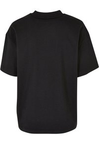 T-shirt noir à manches courtes en coton doux, avec un col rond, une coupe ample, et un dos uni sans motifs ni accents visibles.