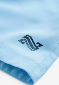 Camicia azzurra a maniche corte con una texture liscia, caratterizzata da un design del logo nero nell'angolo inferiore e cuciture ordinate lungo l'orlo.
