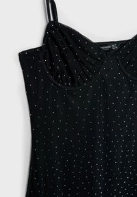 Czarna bezrękawnikowa bluzka z marszczonym biustem, wykonana z prążkowanej tkaniny, ozdobiona wzorem w srebrne kropki, z cienkimi regulowanymi ramiączkami.
