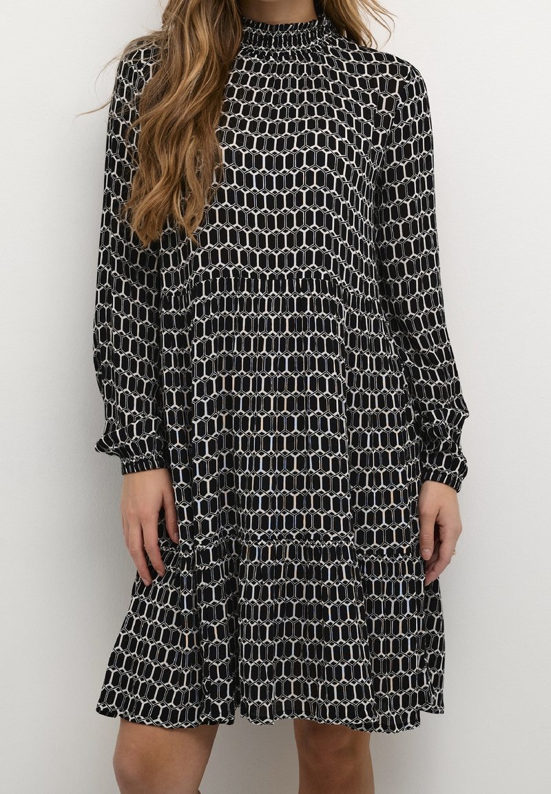 Abito nero a maniche lunghe con un motivo geometrico bianco e tonalità di blu, con scollatura arricciata e orlo arricciato.