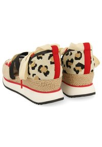 Zapatillas de cuña de lona con estampado de leopardo, con acentos en beige y negro, ribetes rojos y un tacón envuelto en yute. Cuenta con cordones de cinta y una suela texturizada.