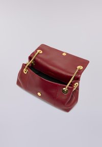 Burgundská kožená kabelka se zlatými detaily, řetízkovými popruhy a zapínáním na knoflík. Otevřený design odhaluje černý interiér. Měkká textura, strukturovaný tvar.