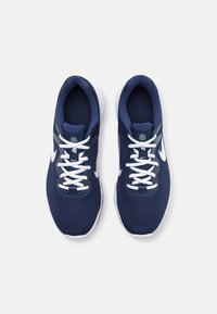 Zapatillas deportivas azul marino con un upper de malla texturizada, cordones blancos y cuello acolchado; presentan un logo blanco de Nike en los laterales.