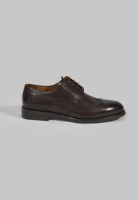Bruine leren dresschoenen met een ronde neus, gedetailleerd brogue-patroon, vetersluiting en een lage gestapelde hak. Gladde afwerking en minimale accenten.