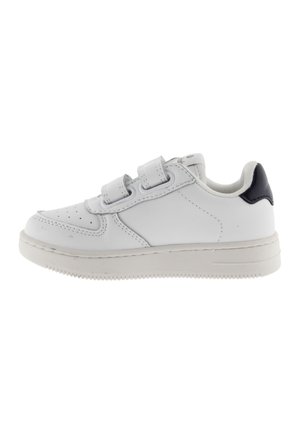 White sneakers with a textured surface, featuring Velcro straps, a rubber sole, and a navy accent on the heel.