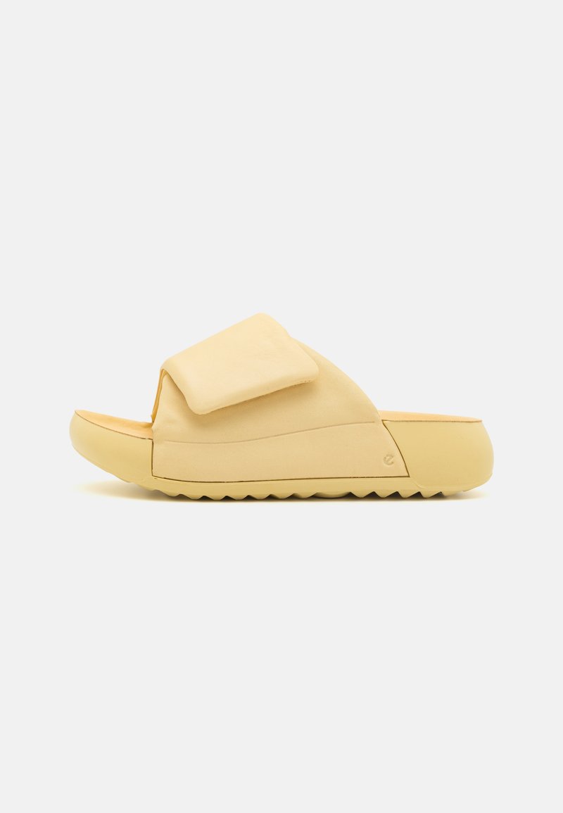 Kollane libisemisjalats pehme ülemise materjaliga, millel on suur velcro rihm ja paks, tekstureeritud talla osa, millel on lainekujundus.
