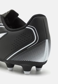 Scarpina da calcio nera con materiale liscio, strisce bianche a contrasto, dettagli perforati e suola testurizzata con tacchetti visibili.