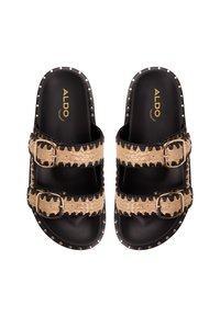 Black and tan slide sandals with two buckled straps. Features woven straw-like material, gold studs along the edge, and a smooth black footbed.