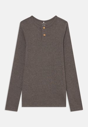 Chemise grise à manches longues, côtelée, avec un col rond et une patte de boutonnage à trois boutons en bois. Texture douce, coupe décontractée.