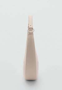 Sac à main beige avec une surface lisse et texturée, doté d'une anse unique fixée par une quincaillerie argentée et d'une silhouette effilée.