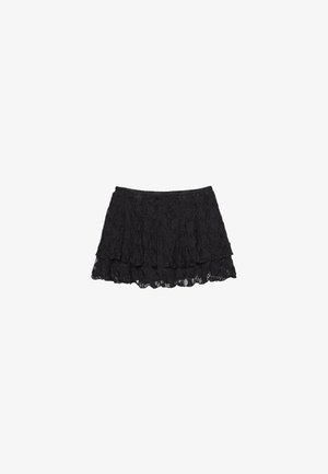 Gonna in pizzo nero con un design a strati, caratterizzata da una superficie texturizzata e un orlo scalloppato. Vita elasticizzata per una vestibilità comoda.