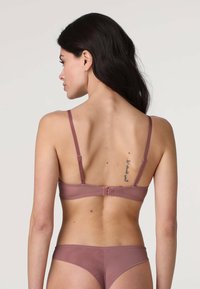 Reggiseno a coppa con ferretto color malva, con spalline regolabili, tessuto strutturato e chiusura a gancio. Finitura liscia, design minimalista e senza imbottitura.