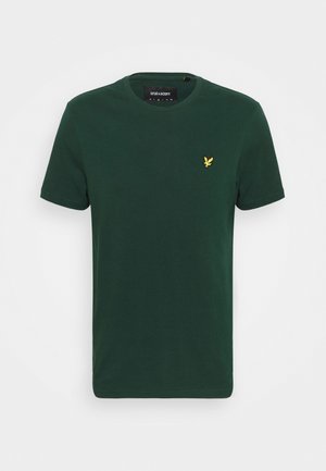 T-shirt en coton vert avec un col rond et des manches courtes, arborant un petit logo d'oiseau jaune sur la partie gauche de la poitrine.